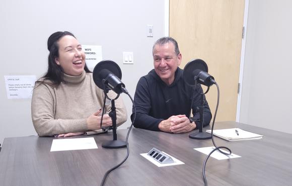 Chelsey and Elmer sit at the podcast table.