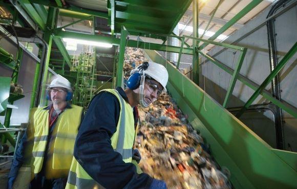 Man sorting waste in recycling plant